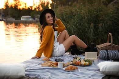 Photo of Young woman spending time on pier at picnic