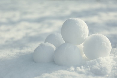 Photo of Perfect round snowballs on snow outdoors, closeup