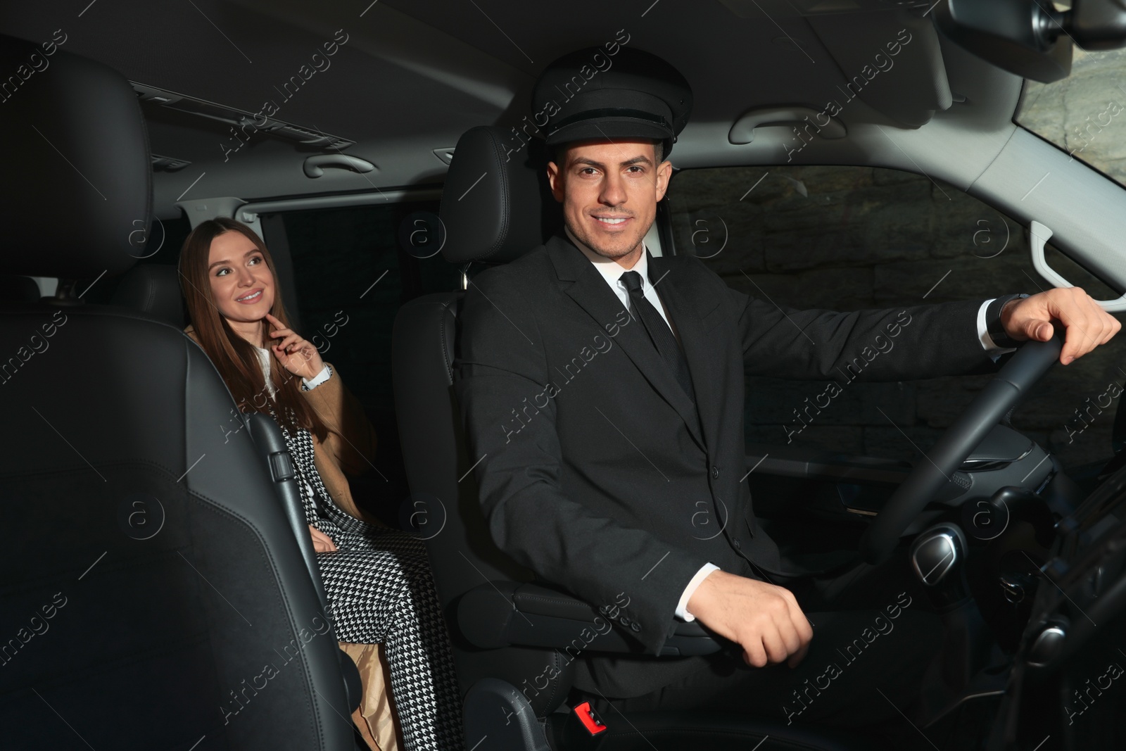 Photo of Professional driver and businesswoman in luxury car. Chauffeur service