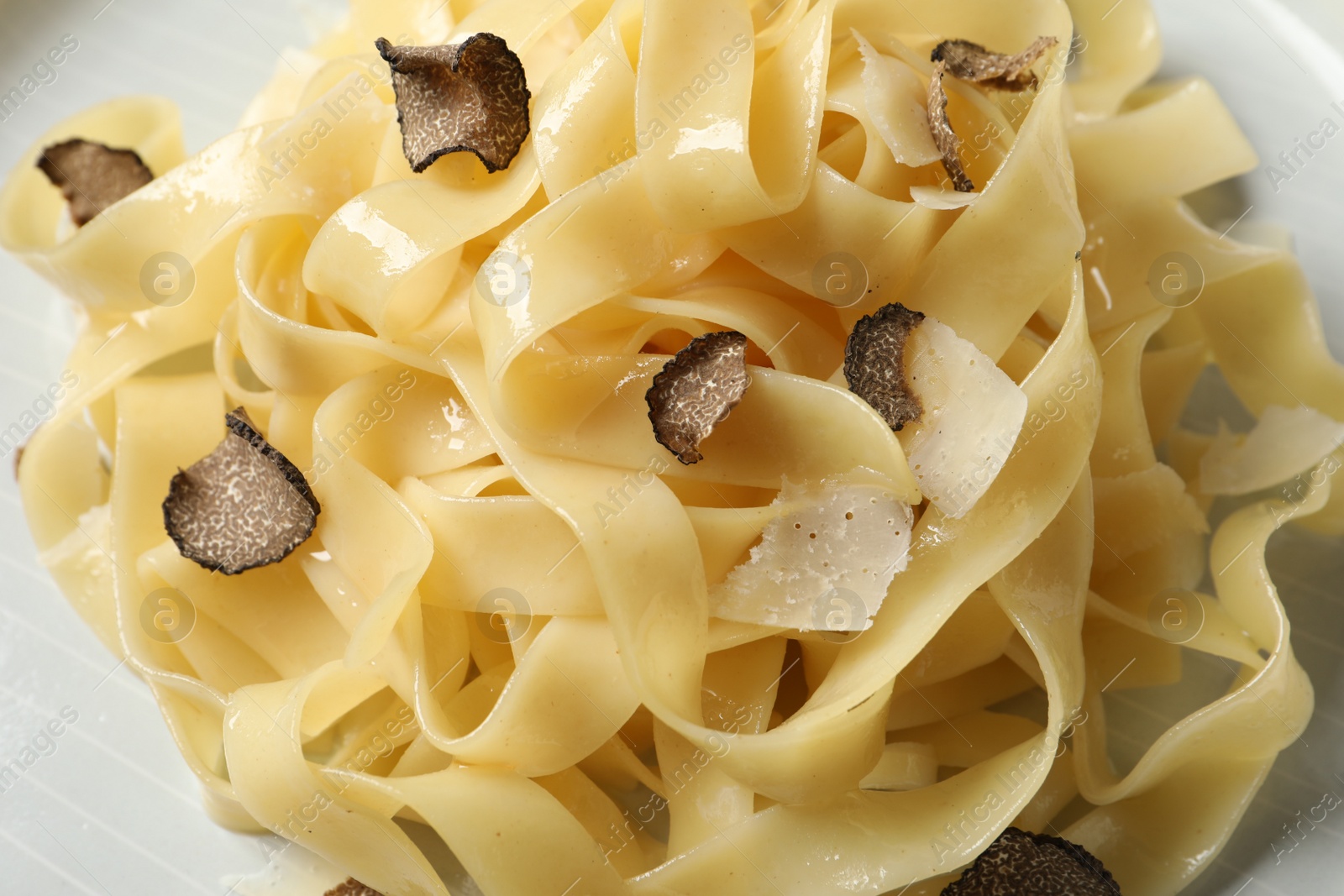 Photo of Delicious pasta with truffle slices on plate, above view