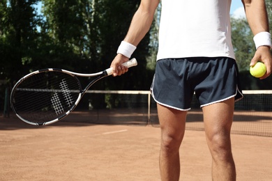 Sportsman playing tennis at court on sunny day, closeup