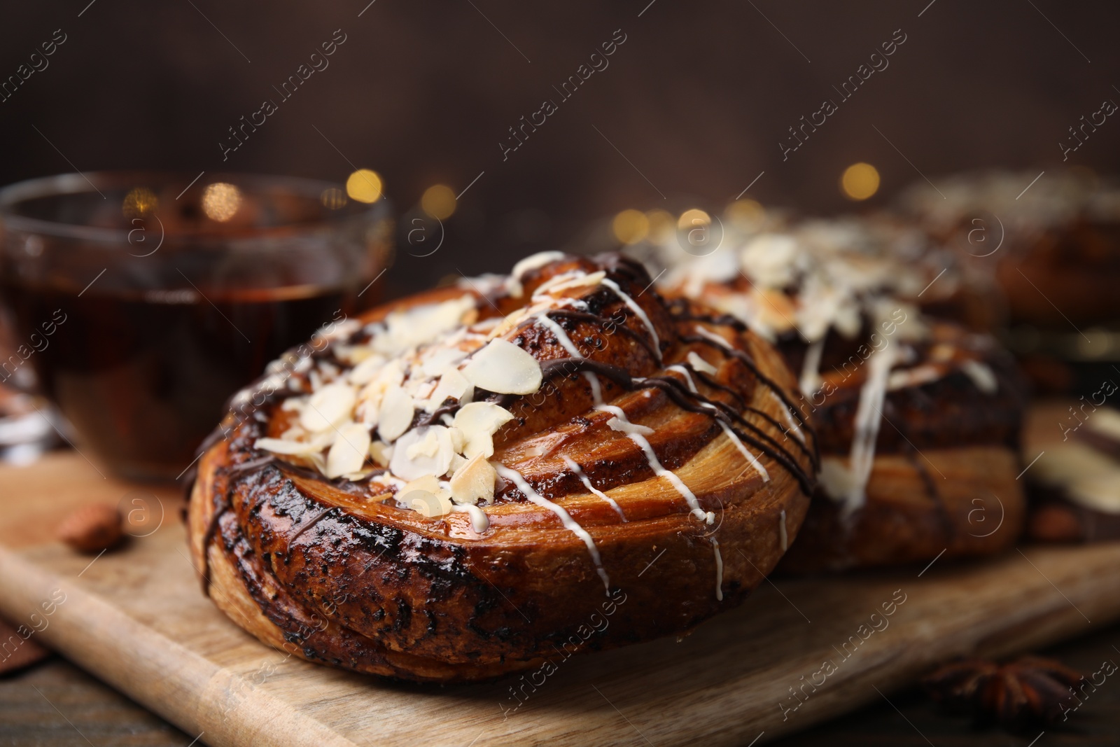 Photo of Delicious rolls with toppings and nuts on wooden table, closeup. Sweet buns