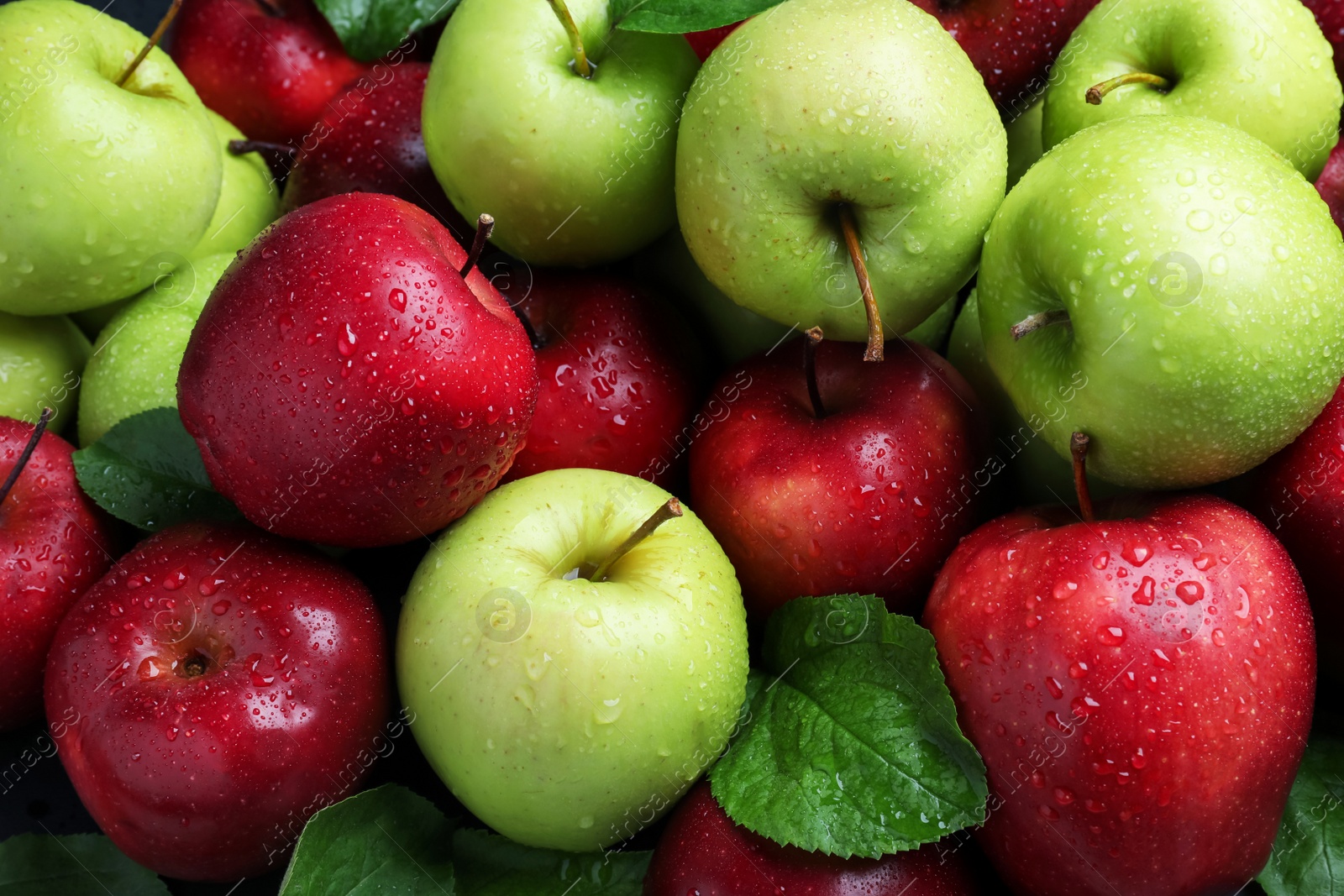 Photo of Fresh ripe green and red apples with water drops as background, top view