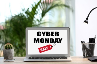 Image of Modern laptop with text Cyber Monday Sale on screen in room 