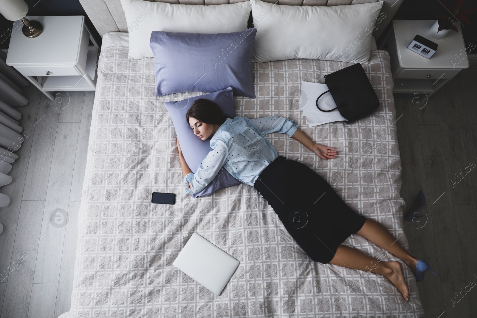 Photo of Exhausted businesswoman in office wear sleeping on bed at home after work, above view