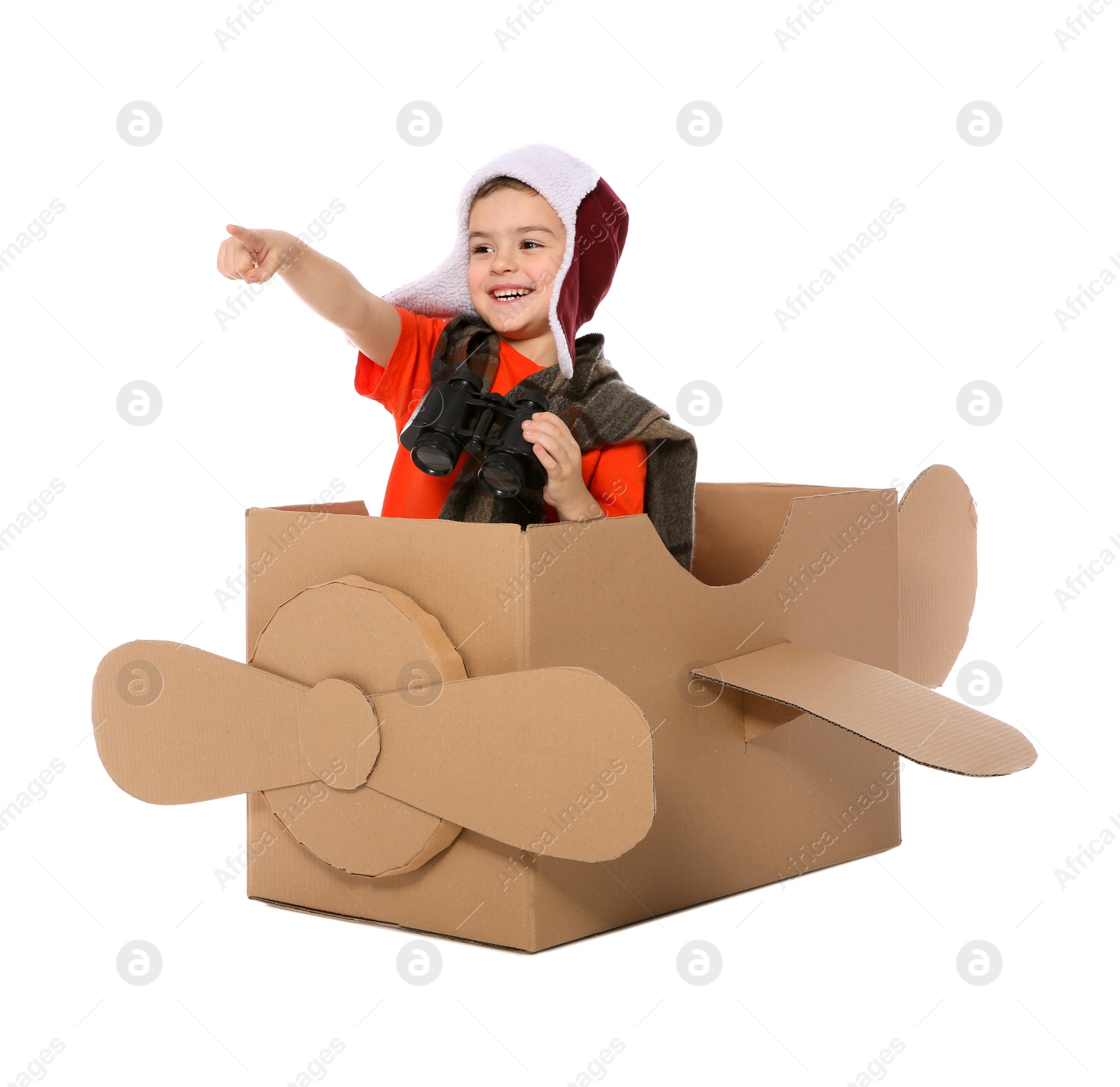 Photo of Cute little boy playing with binoculars and cardboard airplane on white background