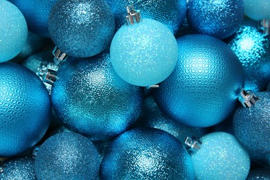 Photo of Light blue Christmas balls as background, closeup