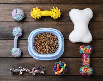 Photo of Flat lay composition with different pet toys and feeding bowl on wooden background
