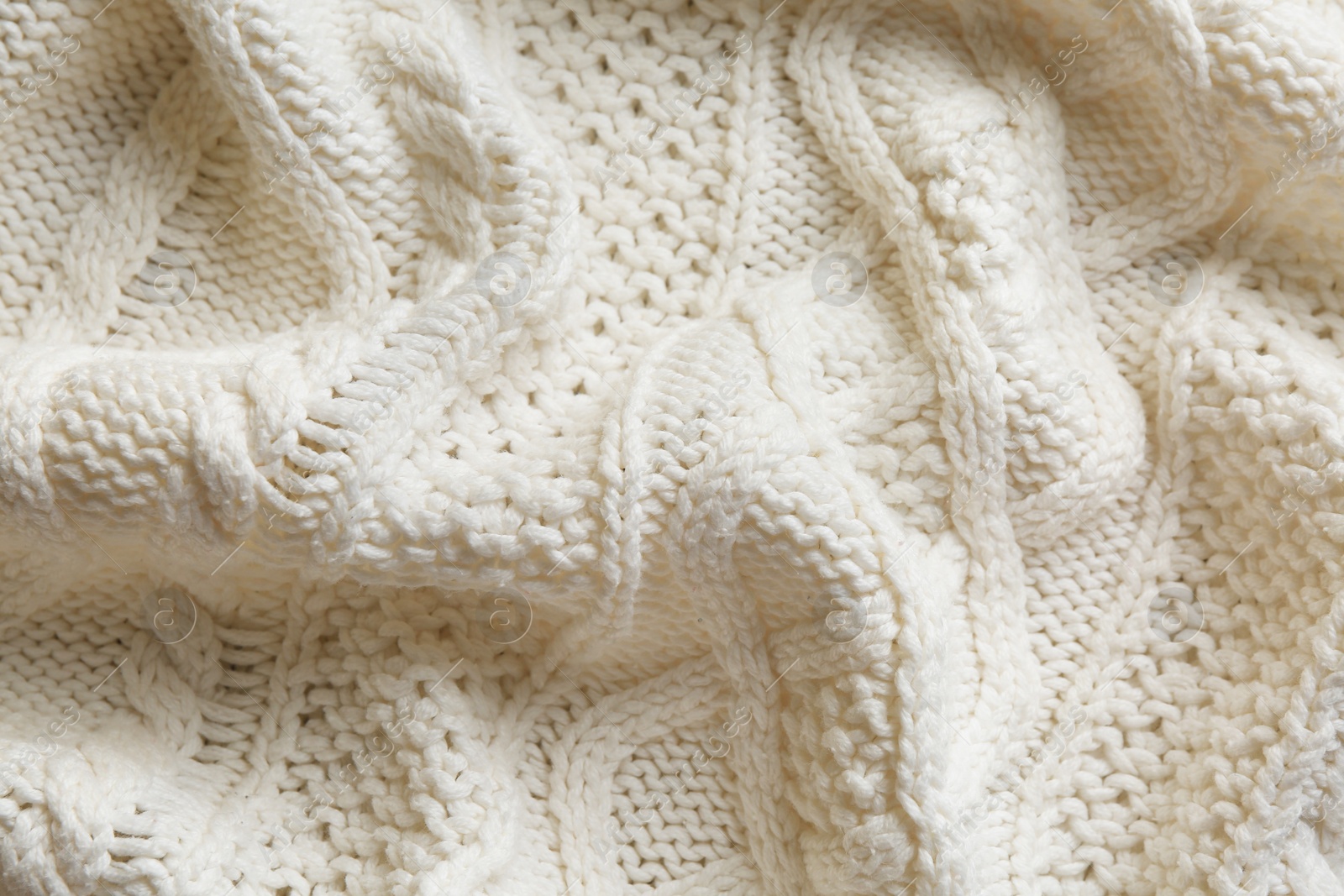 Photo of White knitted fabric with beautiful pattern as background, top view