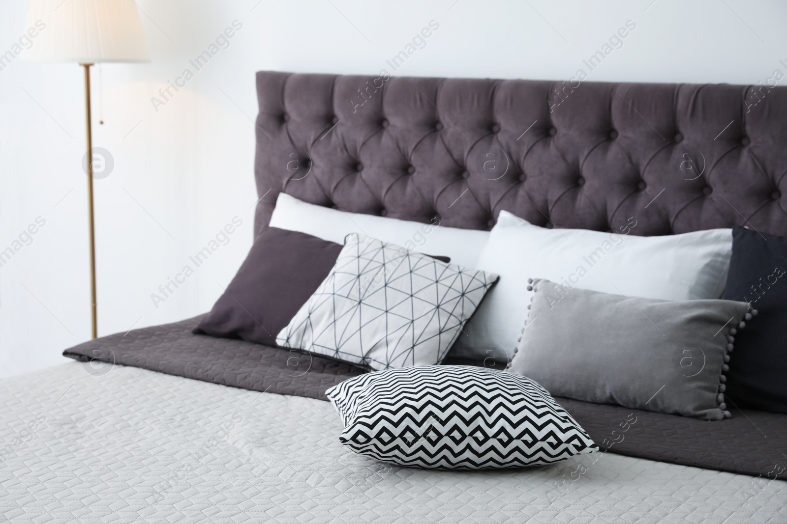 Photo of Soft pillows on modern bed in room