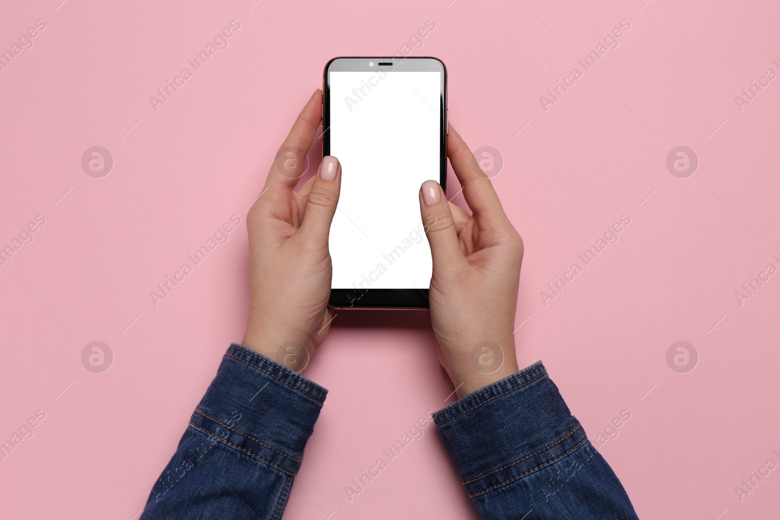 Photo of Woman with smartphone on pink background, top view