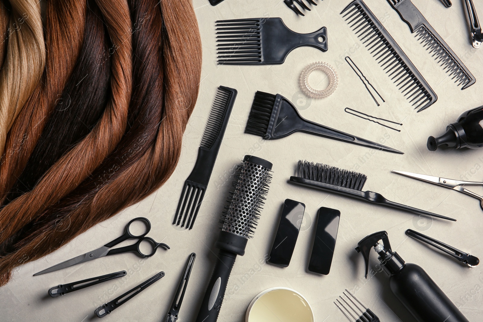 Photo of Flat lay composition with different locks of hair and tools on color background