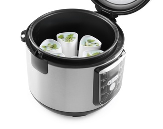 Open multi cooker with cups of homemade yogurt isolated on white