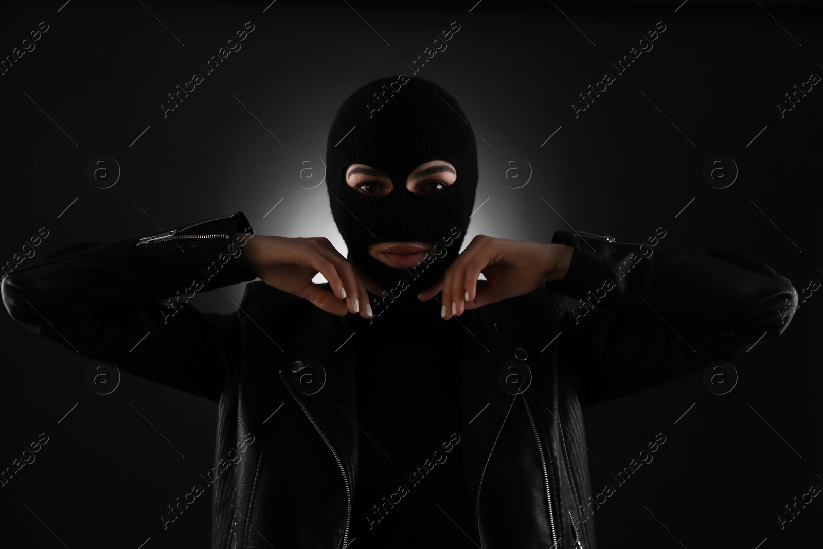 Photo of Woman wearing knitted balaclava on black background