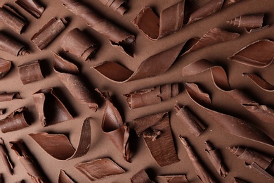 Photo of Flat lay composition with chocolate curls on color background