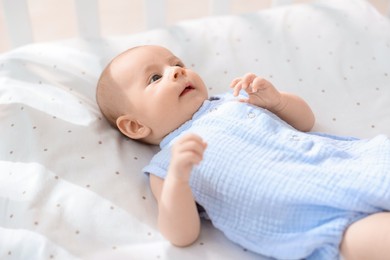 Cute little baby lying in crib at home