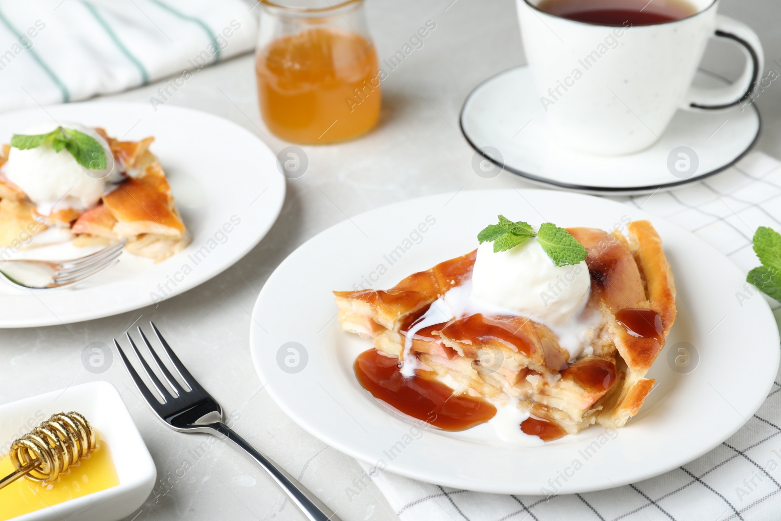 Photo of Slice of traditional apple pie with ice cream served on light marble table