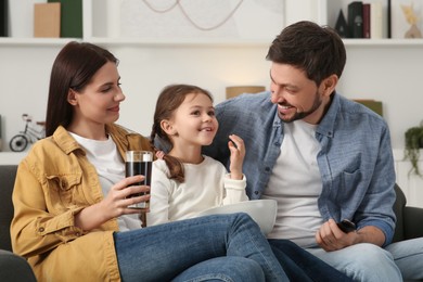 Photo of Happy family spending time together while watching TV at home