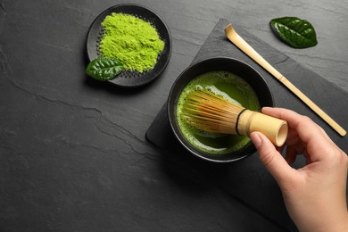 Photo of Woman preparing matcha tea at black table, top view. Space for text