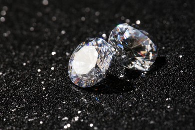 Photo of Two beautiful diamonds on dark shiny background, closeup