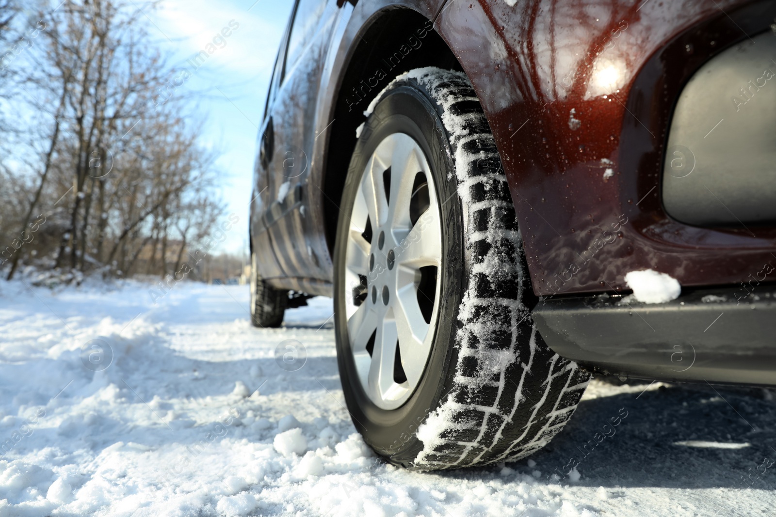 Photo of Car with winter tires on snowy road, closeup view. Space for text