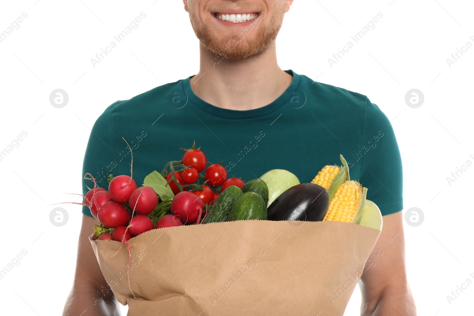 Photo of Young man with bag of fresh vegetables on white background, closeup