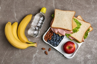 Photo of Flat lay composition with healthy food  on grey table. School lunch