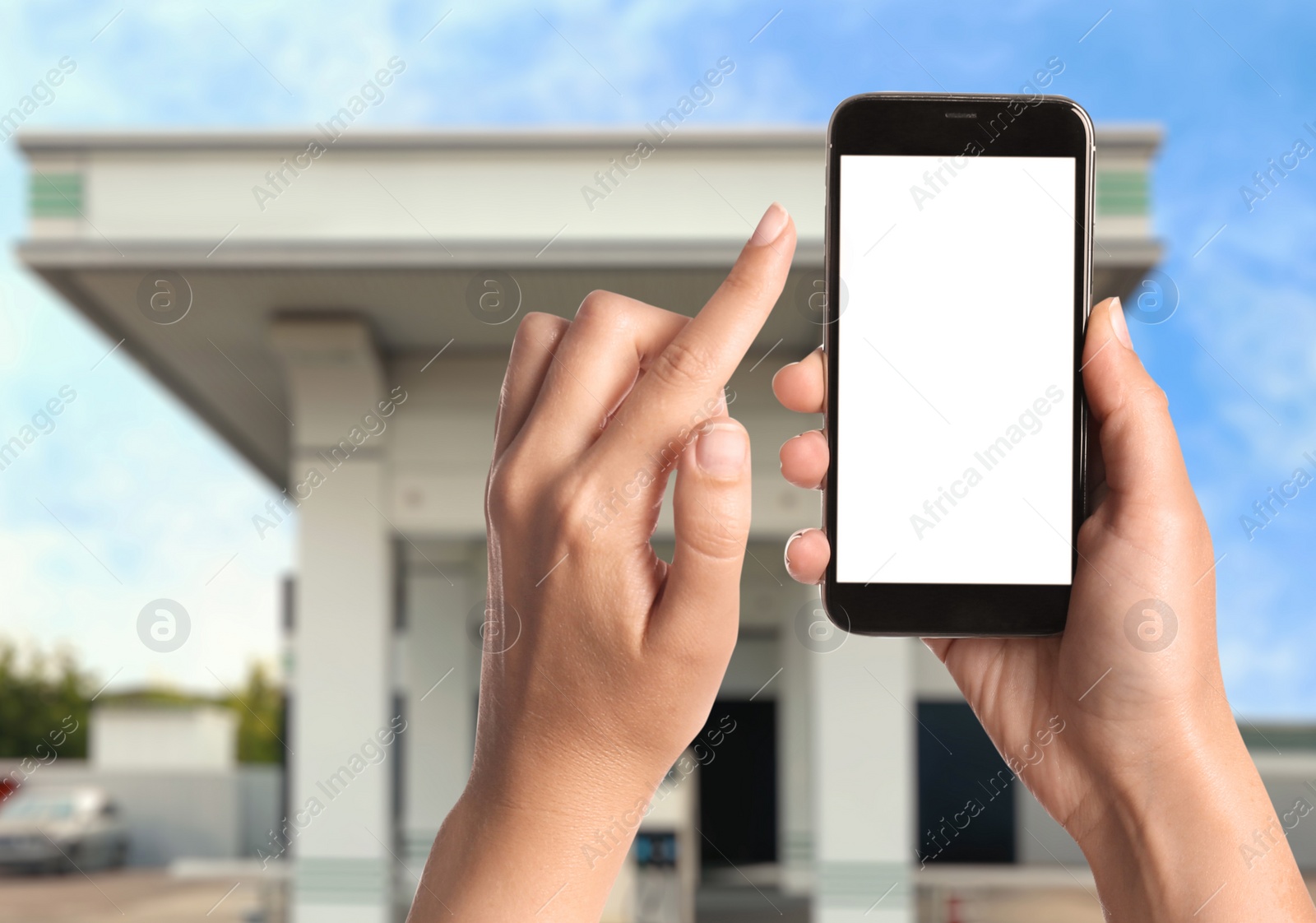 Image of Woman paying for refueling via smartphone at gas station, closeup. Device with empty screen