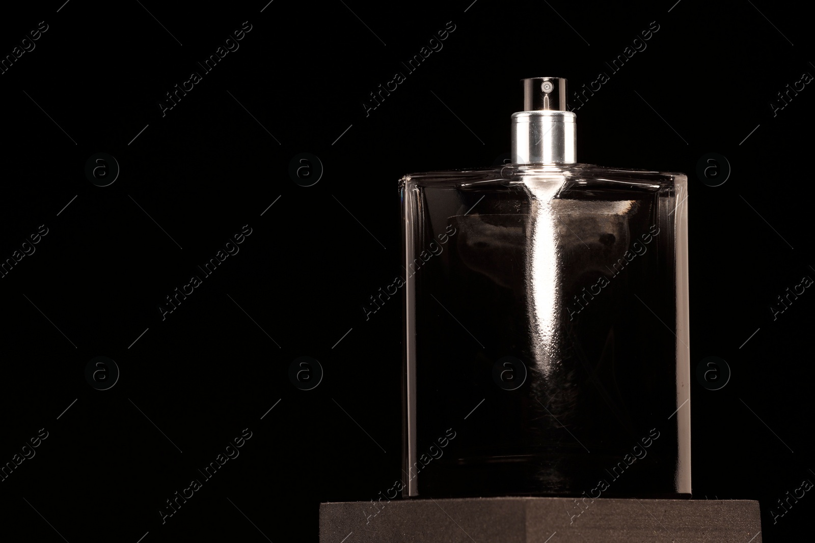 Photo of Luxury men`s perfume in bottle against black background, space for text