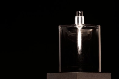 Luxury men`s perfume in bottle against black background, space for text