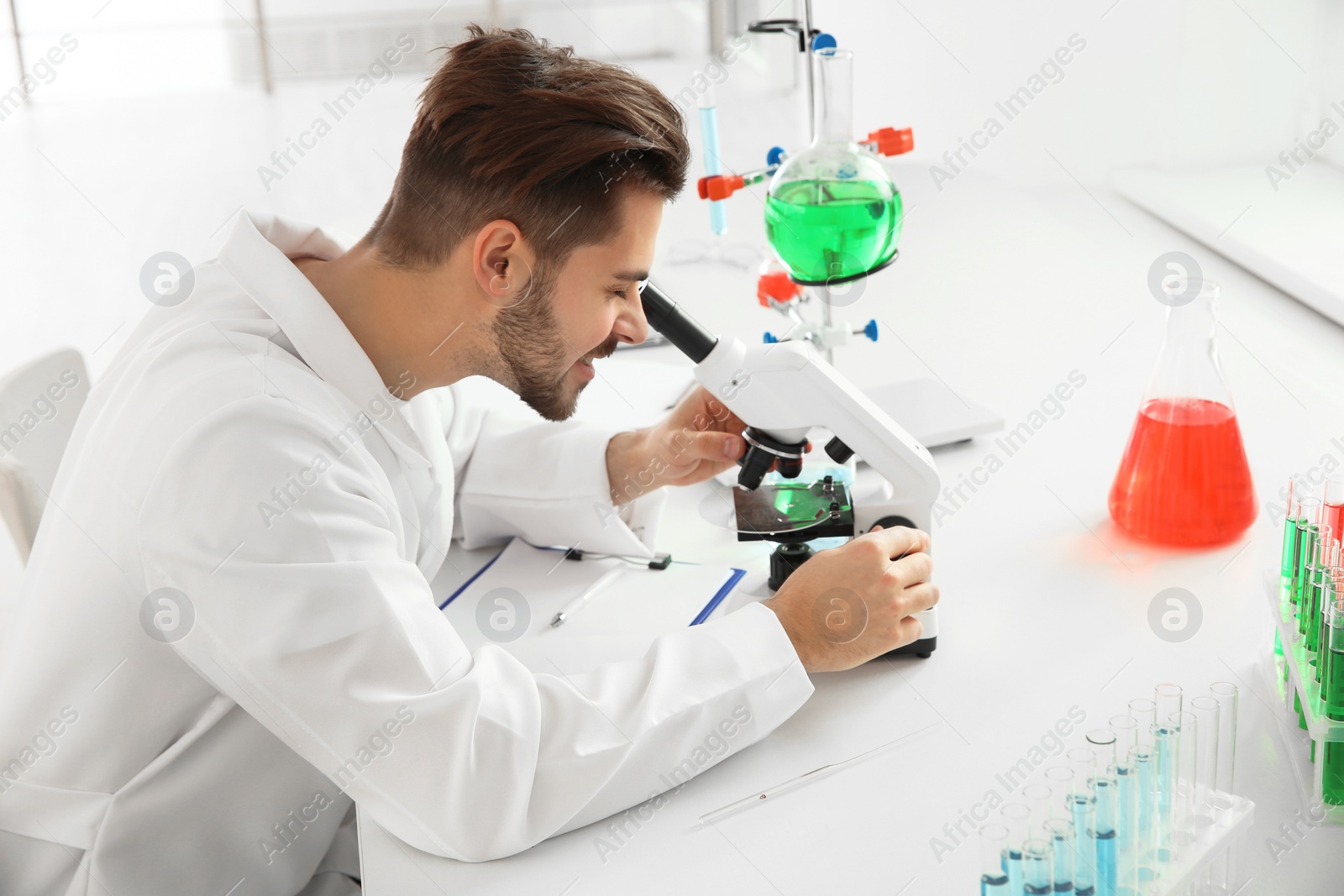 Photo of Medical student working with microscope in modern scientific laboratory