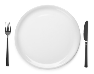 Plate and cutlery on white background, top view