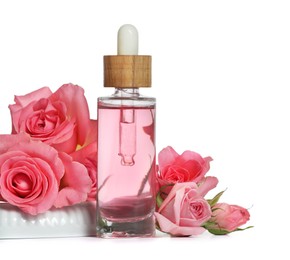 Bottle of essential rose oil and flowers on white background