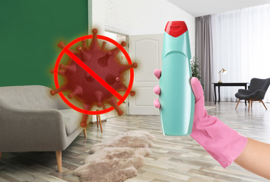 Image of Keep your home virus-free. Woman holding bottle of disinfecting solution in clean room