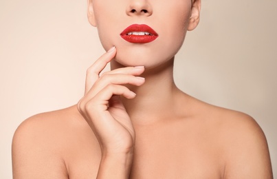 Photo of Beautiful young woman with red lips on color background, closeup