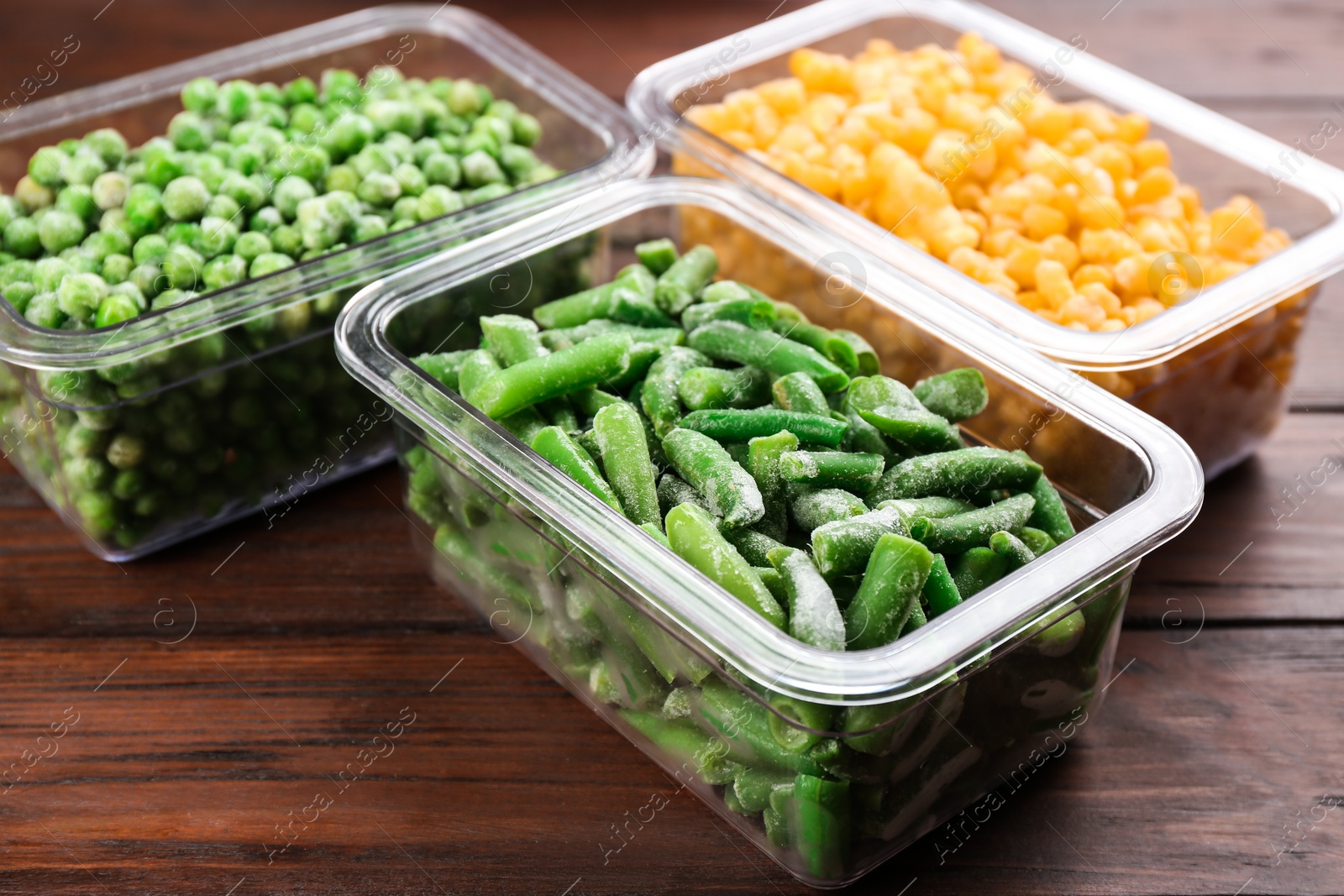 Photo of Different tasty frozen vegetables on wooden table