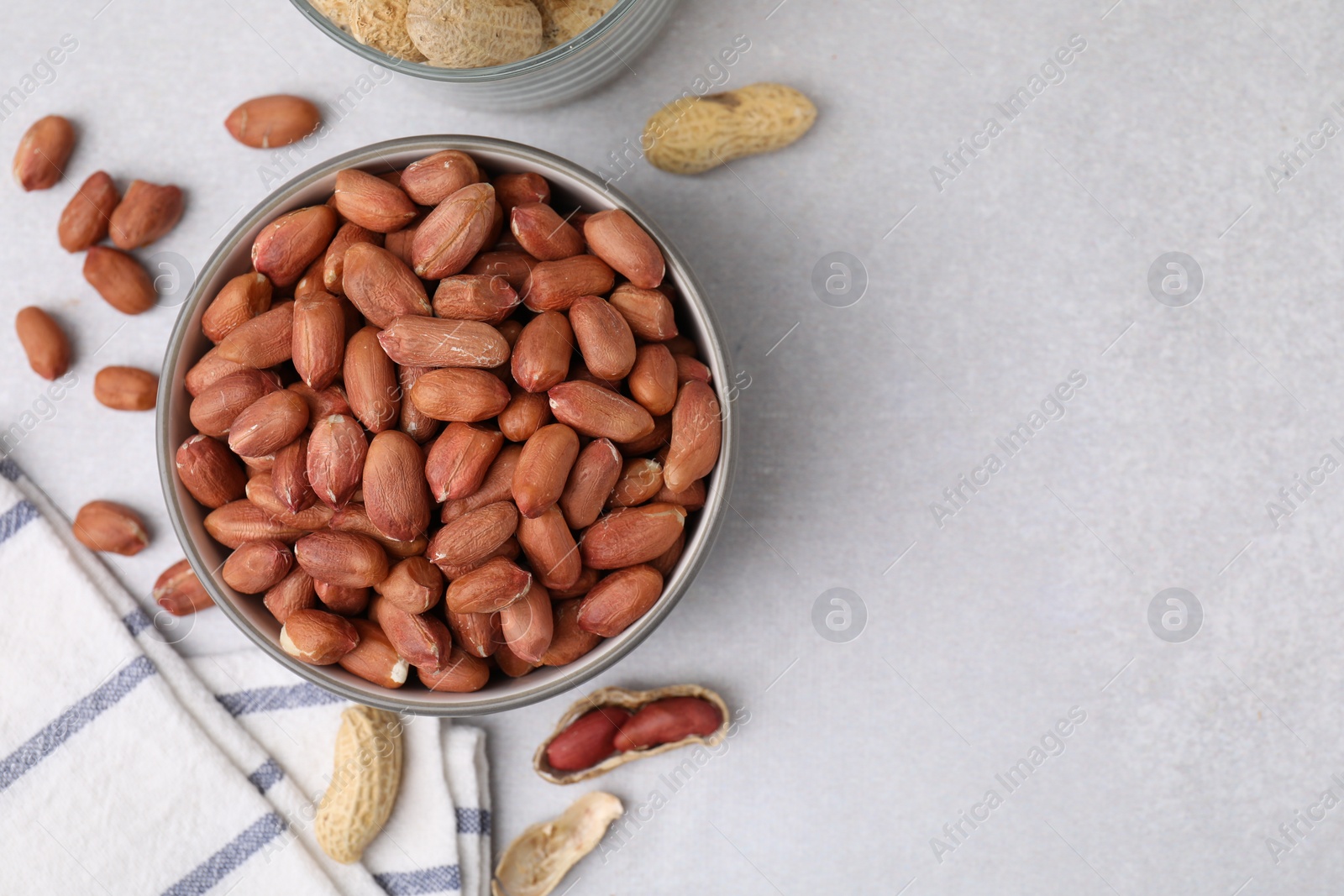 Photo of Fresh unpeeled peanuts on grey table, flat lay. Space for text