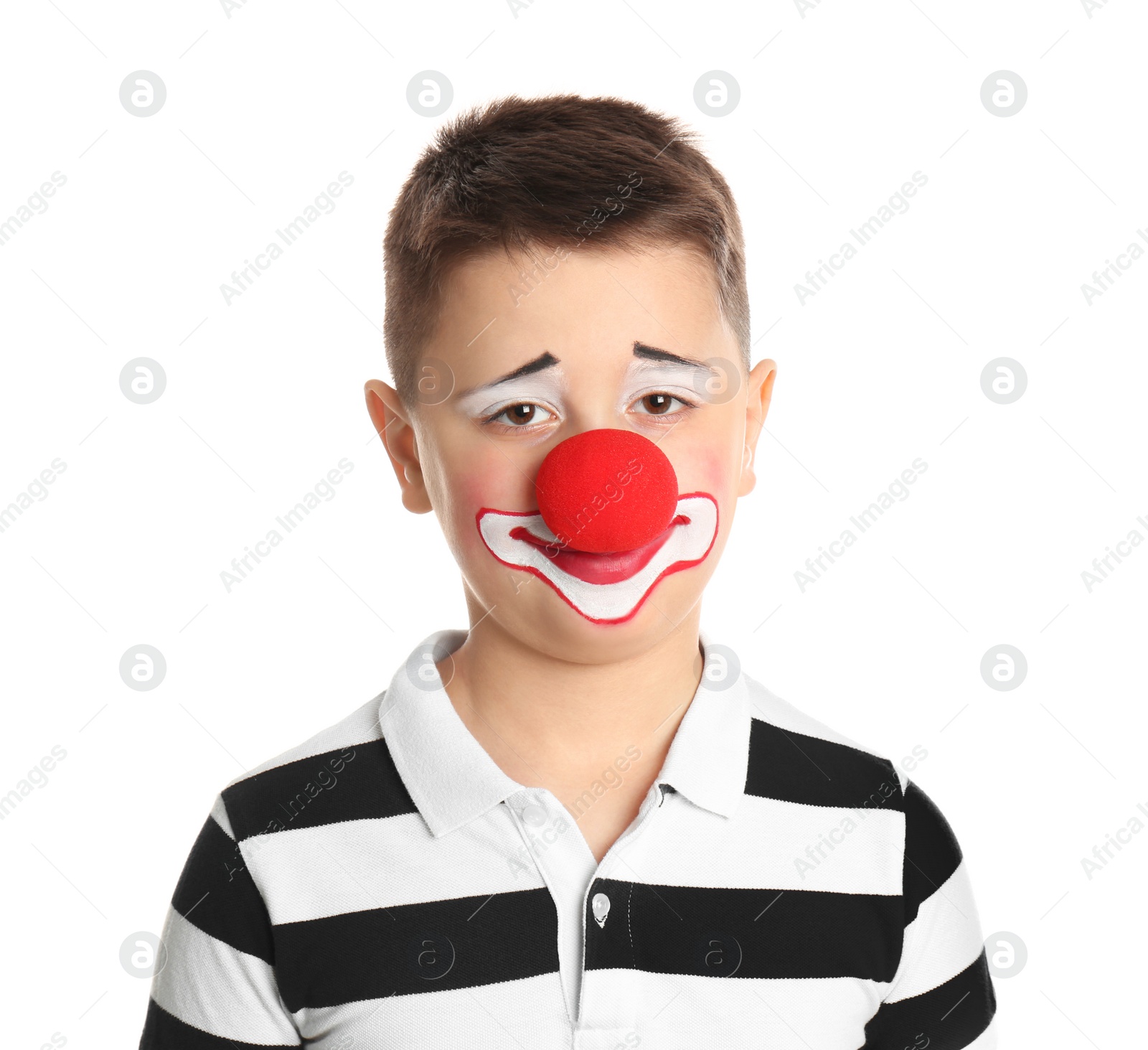 Photo of Preteen boy with clown makeup and nose on white background. April fool's day