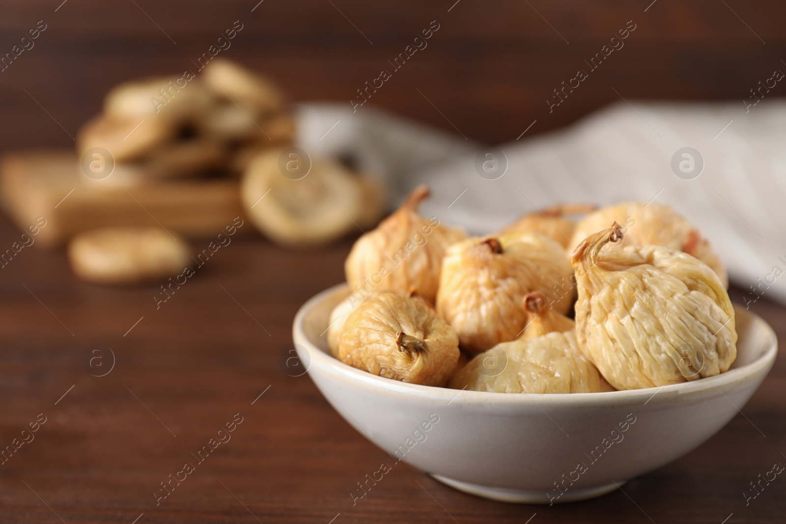 Photo of Tasty dried figs on wooden table, closeup. Space for text