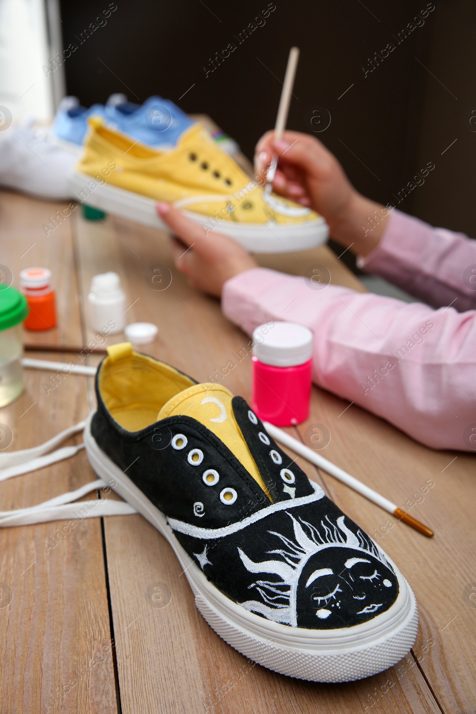 Photo of Amazing customized shoe on wooden table, closeup