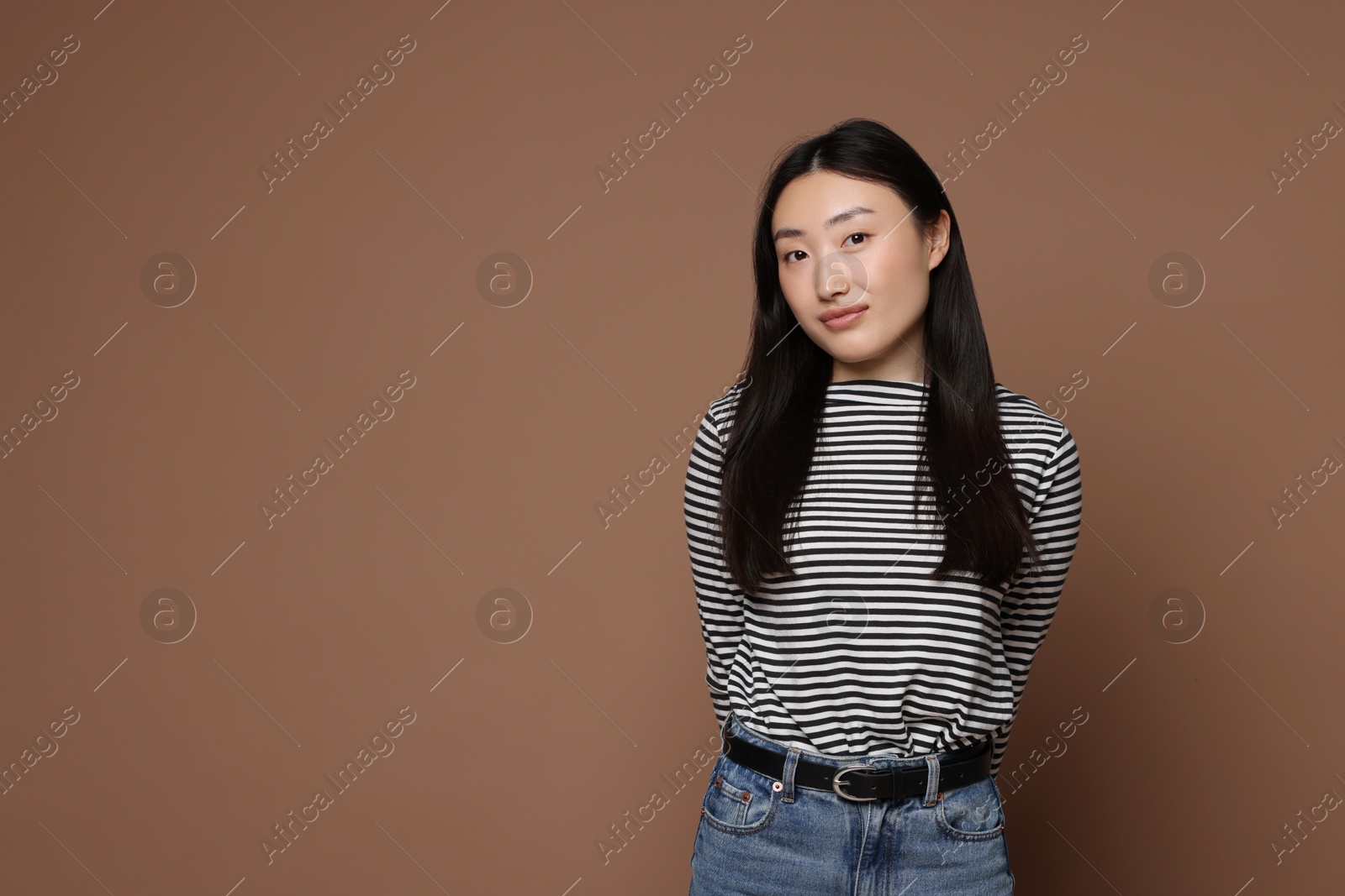 Photo of Portrait of beautiful woman on brown background. Space for text