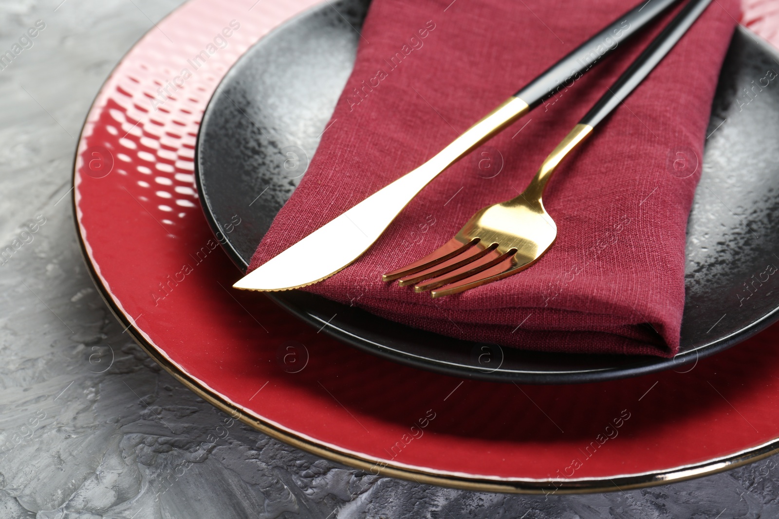 Photo of Clean plates, cutlery and napkin on table, closeup