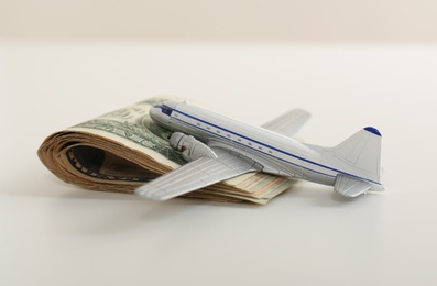 Photo of Toy plane and money on white background. Travel insurance