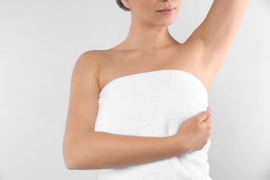 Woman checking her breast on white background, closeup