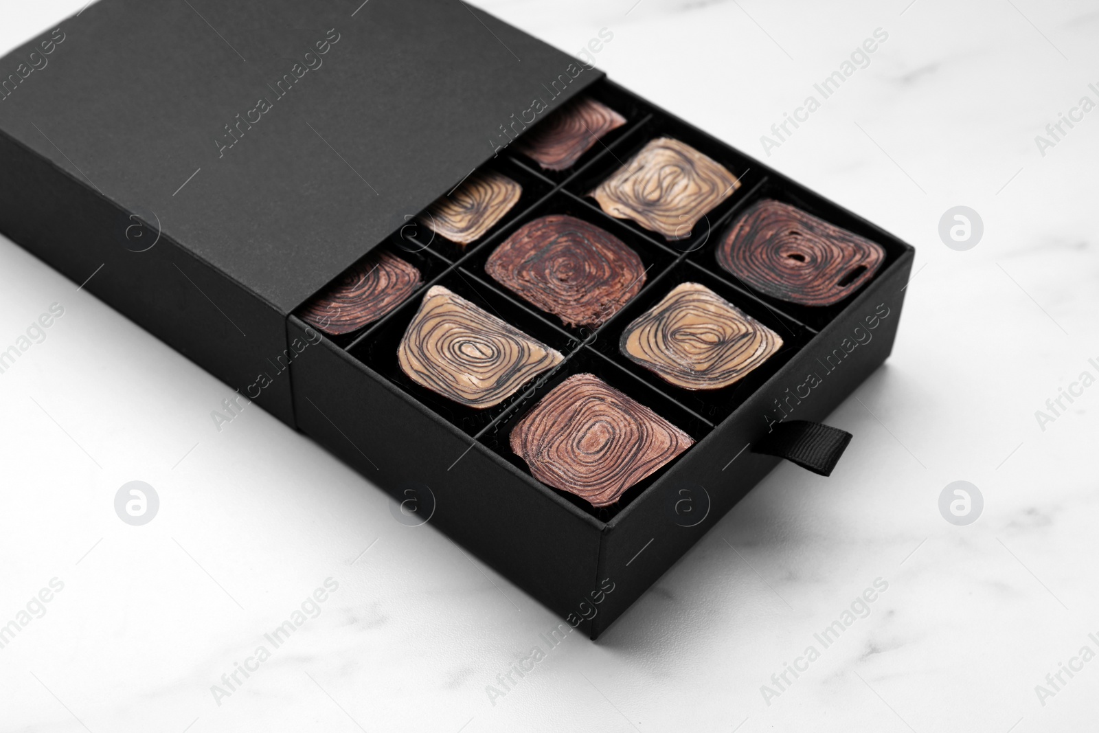 Photo of Box of tasty chocolate candies on white table