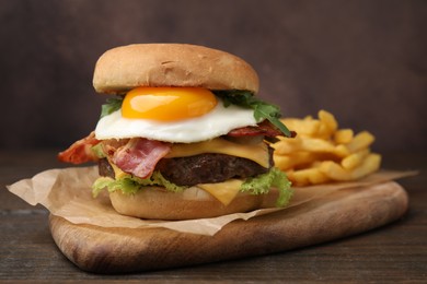 Photo of Delicious burger with fried egg on wooden table, closeup