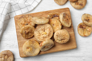 Photo of Tasty dried figs on white wooden table, flat lay