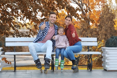 Photo of Portrait of happy family wearing roller skates on bench outdoors