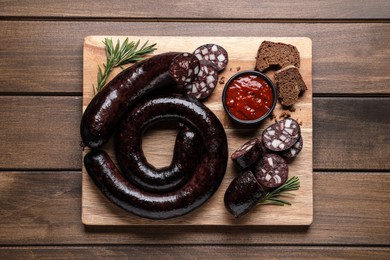 Photo of Tasty blood sausages served on wooden table, top view