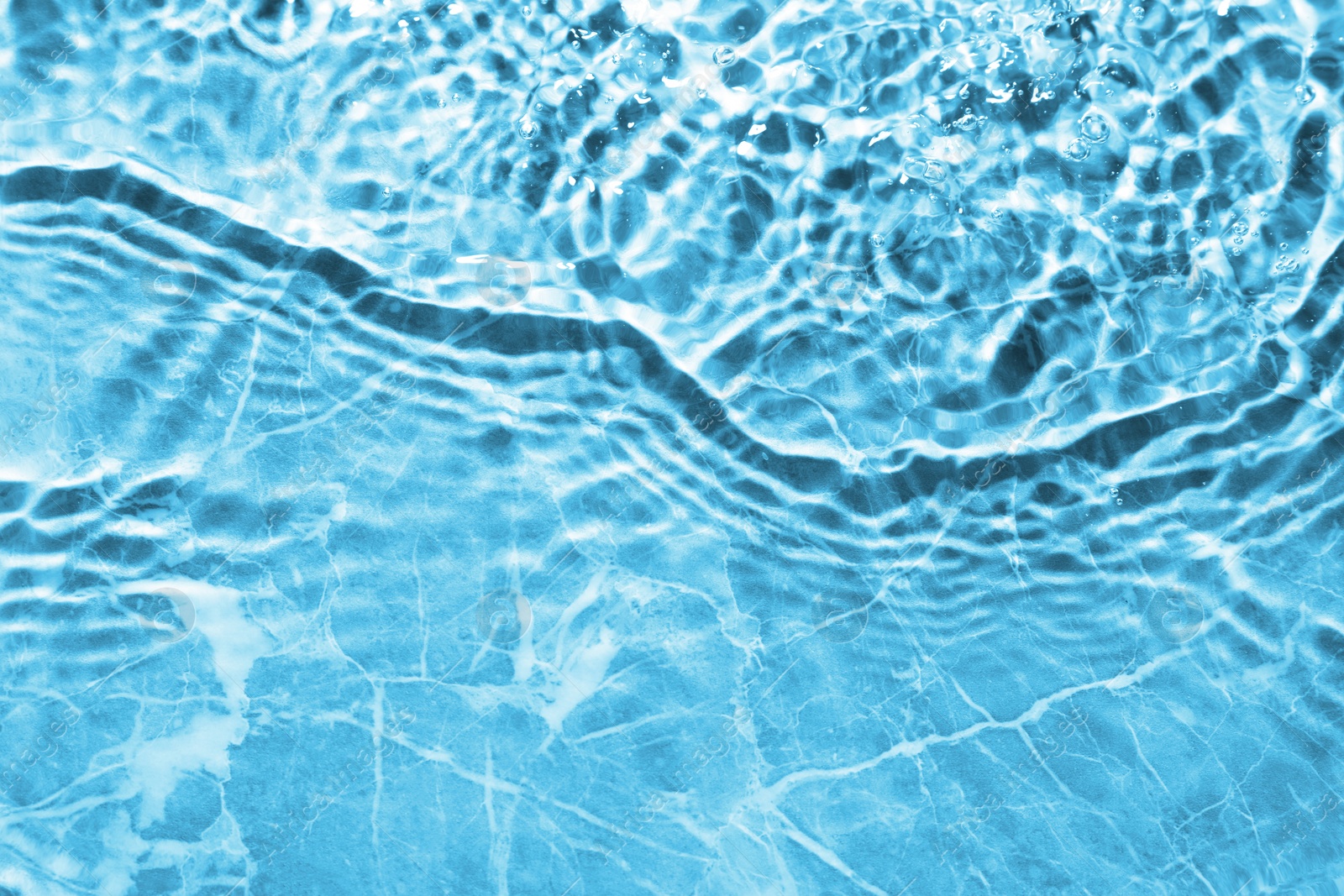 Image of Rippled surface of clear water on light blue background, top view